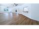 Bright, open living room featuring hardwood floors, ceiling fans, and a view of the fireplace through glass doors at 6602 Winding Brook Dr, New Port Richey, FL 34655