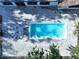 Overhead aerial view of a rectangular backyard pool with an adjoined patio and trees at 6602 Winding Brook Dr, New Port Richey, FL 34655