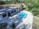 Aerial view of a backyard pool with an adjoined patio and a white house with dark-trimmed windows at 6602 Winding Brook Dr, New Port Richey, FL 34655