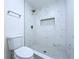 Elegant shower with marble-style tiles, a built-in niche, and stylish fixtures at 6602 Winding Brook Dr, New Port Richey, FL 34655