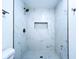 Modern shower with white marble-style tile and a built-in niche at 6602 Winding Brook Dr, New Port Richey, FL 34655