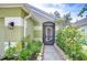 Inviting front entrance with a screened door, beautiful landscaping, and a stone walkway at 6628 Summer Haven Dr, Riverview, FL 33578
