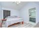 Cozy main bedroom with gray wood flooring, a ceiling fan, and an ensuite bathroom at 6628 Summer Haven Dr, Riverview, FL 33578