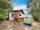 Serene backyard featuring a pergola-covered hot tub, lush tropical plants, and a stone patio at 7125 S Shore S Dr, St Petersburg, FL 33707