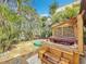 Landscaped backyard featuring a wooden pergola-covered hot tub, creating a private outdoor oasis at 7125 S Shore S Dr, St Petersburg, FL 33707