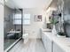 Modern bathroom featuring a glass shower with a seat, dual sink vanity, and stylish decorative tile accents at 7125 S Shore S Dr, St Petersburg, FL 33707