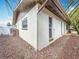Exterior angle of a home surrounded by a rock garden and featuring an access point to the backyard at 7125 S Shore S Dr, St Petersburg, FL 33707