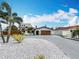 Charming single-story home featuring an arched entryway, well-manicured yard, and two-car garage at 7125 S Shore S Dr, St Petersburg, FL 33707