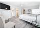Bright main bedroom featuring wood-look floors, a ceiling fan, TV, and neutral decor at 7125 S Shore S Dr, St Petersburg, FL 33707