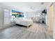 Bright main bedroom featuring luxury floors, a ceiling fan, and a beach themed painting at 7125 S Shore S Dr, St Petersburg, FL 33707