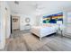 Large main bedroom boasts wood-look floors, white walls, ceiling fan, and neutral decor at 7125 S Shore S Dr, St Petersburg, FL 33707