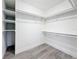 The walk-in closet has wood-look flooring and features built in shelving and hanging storage at 7125 S Shore S Dr, St Petersburg, FL 33707
