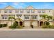Attractive exterior townhome row with neutral paint, purple shutters, paved driveways and lush landscaping at 807 Callista Cay Loop, Tarpon Springs, FL 34689