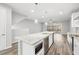 Kitchen featuring an expansive island with stone countertops, stainless steel appliances, and a wine cooler at 807 Callista Cay Loop, Tarpon Springs, FL 34689