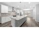 Bright kitchen with a large island featuring granite countertops, stainless steel appliances, and wood-look flooring at 807 Callista Cay Loop, Tarpon Springs, FL 34689