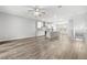 Spacious open-concept living room featuring wood floors, recessed lighting, ceiling fan, and kitchen view at 807 Callista Cay Loop, Tarpon Springs, FL 34689
