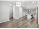 Bright living area showcasing wood floors and contemporary lighting, with a kitchen and staircase in view at 807 Callista Cay Loop, Tarpon Springs, FL 34689