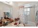 The bathroom has a double sink, toilet, and shower/tub with a decorative curtain and sliding glass doors at 953 Tropical Nw Ave, Port Charlotte, FL 33948