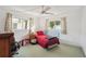 Bright bedroom features a ceiling fan, two windows with decorative curtains, and a blue metal bed frame at 953 Tropical Nw Ave, Port Charlotte, FL 33948