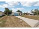 A well-maintained single-story home with a driveway, grass lawn and mature landscaping at 953 Tropical Nw Ave, Port Charlotte, FL 33948