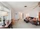 Bright living room with a cozy sofa, large window, and an electric fireplace creating a warm ambiance at 953 Tropical Nw Ave, Port Charlotte, FL 33948