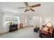 Living room showcasing neutral carpet, ceiling fan, and abundant natural light streaming through the window at 953 Tropical Nw Ave, Port Charlotte, FL 33948