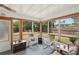 Relaxing sunroom with light gray floors and screened windows offering an abundance of natural light at 953 Tropical Nw Ave, Port Charlotte, FL 33948