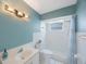 Bright bathroom featuring blue walls, tiled shower, and white vanity at 965 S Florida Ave, Tarpon Springs, FL 34689