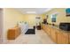 Bright laundry room features extensive cabinetry, stone counters, and tile floors at 965 S Florida Ave, Tarpon Springs, FL 34689