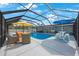 Enclosed pool area with multiple seating options and shaded areas for outdoor relaxation and entertainment at 965 S Florida Ave, Tarpon Springs, FL 34689