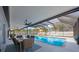 Enclosed pool area featuring a dining table, seating area, and refreshing blue pool water at 965 S Florida Ave, Tarpon Springs, FL 34689