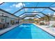 Spacious screened pool area with ample seating and a beautiful clear swimming pool at 965 S Florida Ave, Tarpon Springs, FL 34689