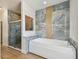 Luxury bathroom with soaking tub, glass shower, and marble-look tiled accent wall at 9709 Bay Colony Dr, Riverview, FL 33578