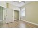 Bedroom boasts wood-look floors, closet with bi-fold doors, and window at 9709 Bay Colony Dr, Riverview, FL 33578