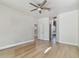 Spacious bedroom with wood floors, ceiling fan, and hallway leading to other areas at 9709 Bay Colony Dr, Riverview, FL 33578