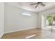 Sun-filled bedroom with modern ceiling fan, wood floors, and a decorative arched window at 9709 Bay Colony Dr, Riverview, FL 33578