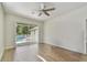 Bright bedroom features wood floors, ceiling fan, and sliding glass doors leading to a pool at 9709 Bay Colony Dr, Riverview, FL 33578