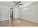 Bedroom showcasing a ceiling fan, arch window, wood floors, and a hallway at 9709 Bay Colony Dr, Riverview, FL 33578