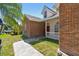 Attractive brick and white home with stone pathway, a red door, and well-maintained landscaping at 9709 Bay Colony Dr, Riverview, FL 33578