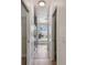 Hallway features wood-look flooring, arched window, with access to shower and closets at 9709 Bay Colony Dr, Riverview, FL 33578