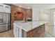 Kitchen featuring a large island with marble countertop, brick arch, and stainless appliances at 9709 Bay Colony Dr, Riverview, FL 33578