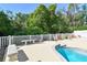 View of the pool area featuring a pool, concrete patio, benches, and white fence at 9709 Bay Colony Dr, Riverview, FL 33578