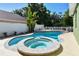 In-ground pool with a spa, bench, and mature landscaping at 9709 Bay Colony Dr, Riverview, FL 33578