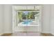 View of a sparkling pool and landscaped backyard visible through sliding glass doors at 9709 Bay Colony Dr, Riverview, FL 33578