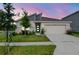 Charming single-story home featuring a modern design, well-manicured lawn, and a two-car garage at twilight at 9795 Crescent Ray Dr, Wesley Chapel, FL 33545