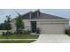 Charming single-Gathering home featuring stone accents, a two-car garage, and a well-manicured lawn at 9795 Crescent Ray Dr, Wesley Chapel, FL 33545