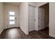 Hallway features wood-look floors, white doors, and modern design, leading to other areas of the home at 9795 Crescent Ray Dr, Wesley Chapel, FL 33545