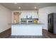 A bright and airy kitchen with white cabinets, stainless steel appliances, and a large center island at 9795 Crescent Ray Dr, Wesley Chapel, FL 33545