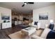 Open-concept living room with a view into the kitchen, featuring neutral tones and modern décor at 9795 Crescent Ray Dr, Wesley Chapel, FL 33545