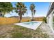 Fenced in backyard with a small pool, grass, and decorative gravel area at 9831 Scenic Dr, Port Richey, FL 34668